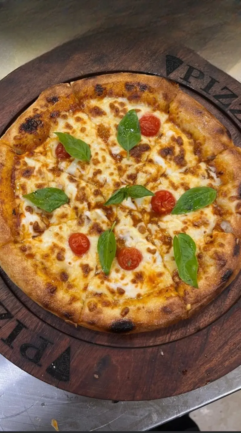 Wood-fired pizza with basil and cherry tomatoes